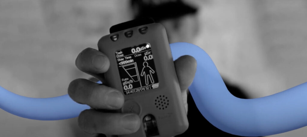 Black and white picture of a person holding a Tracerco PED with blue swirl